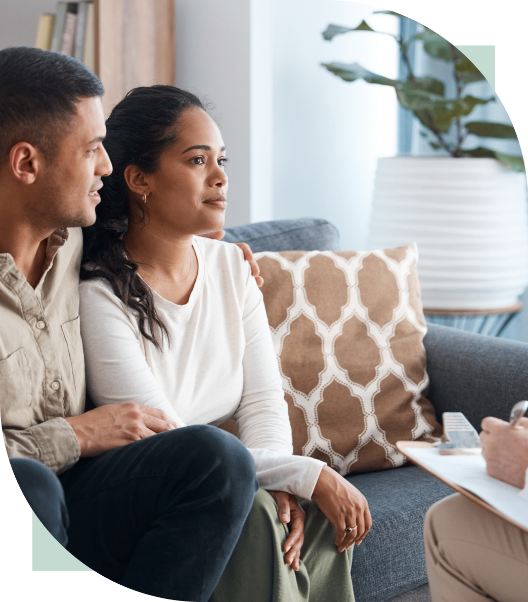 A couple attentively listening to a professional in a cozy living room.